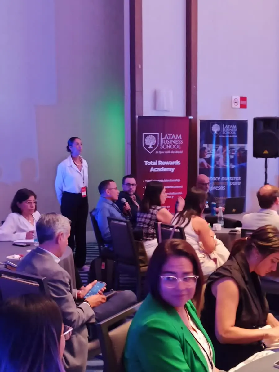 Ronda de preguntas: una participante toma el micrófono desde su mesa
