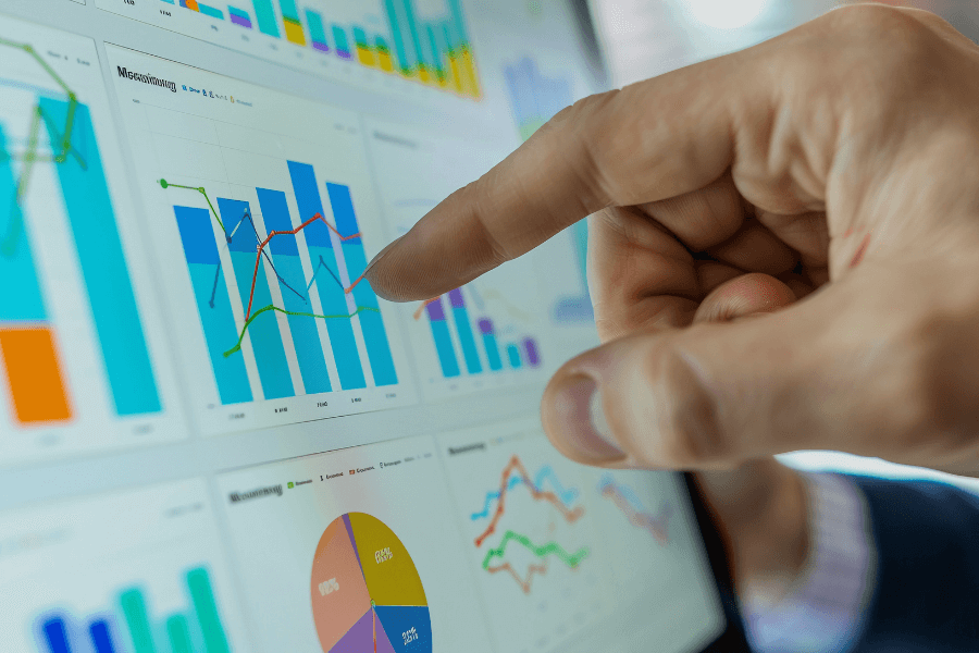Mano señalando gráficos de barras y líneas en un dashboard digital, representando el análisis de datos en People Analytics y Recursos Humanos.
